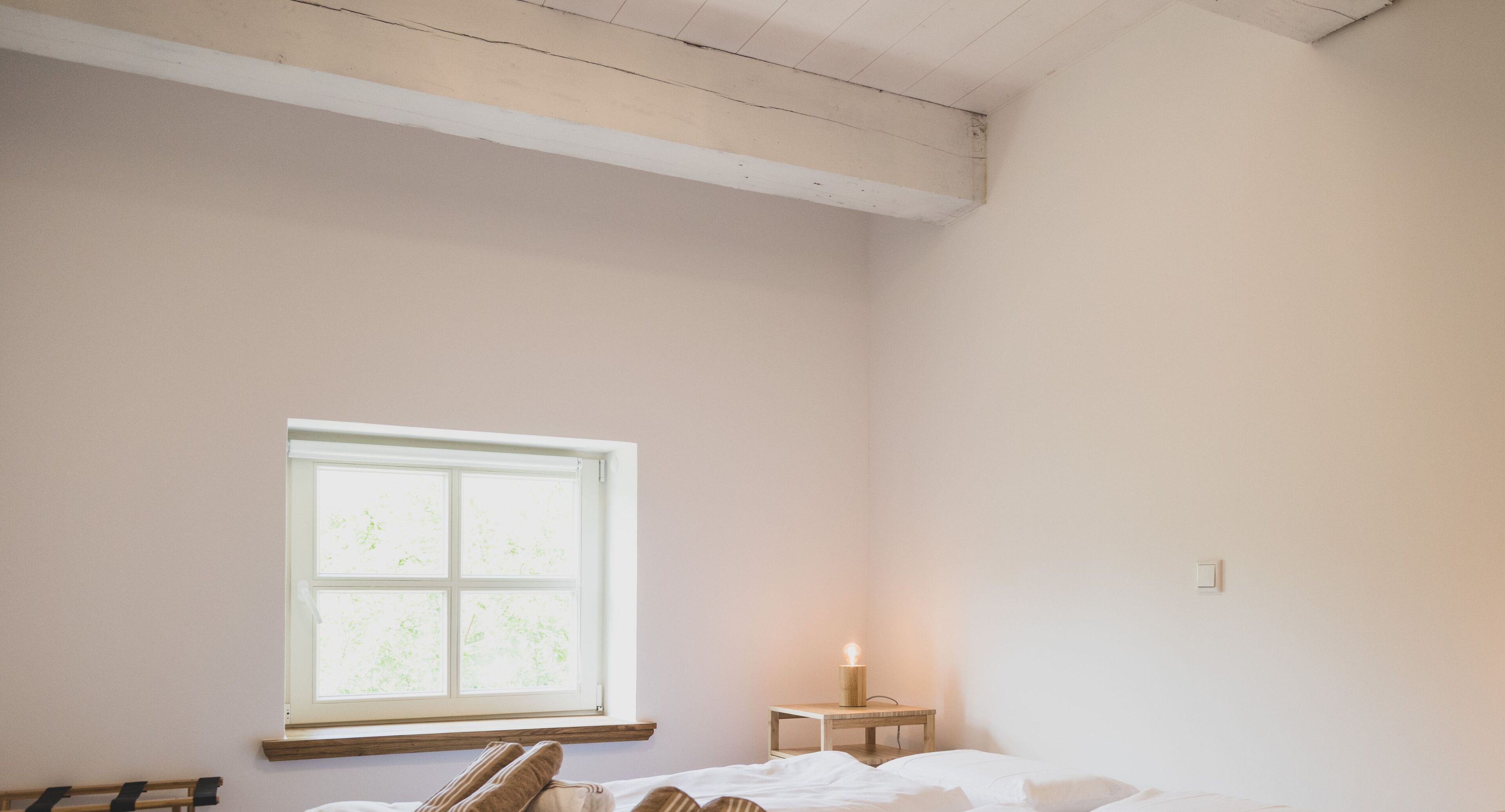 Una camera da letto con un letto singolo, un comodino, una finestra e un tavolino.