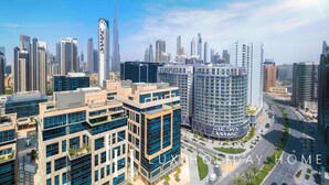 A high-rise building with a curved facade and a sign that reads "DAMAC". - LUX The Pad Executive Suite 2 (Dubai)