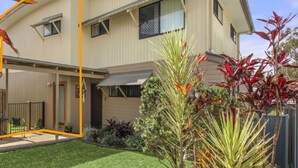 A two-story house with a covered patio, a fenced yard, and a variety of plants. - Mary St 3, Unit 2, Caloundra (Caloundra)