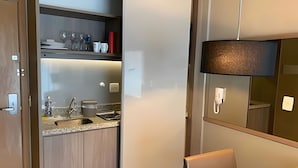 A modern kitchen with a built-in sink, a countertop, and a wall-mounted light fixture. - Brisas do Lago - apartamento 7 (Brasília)