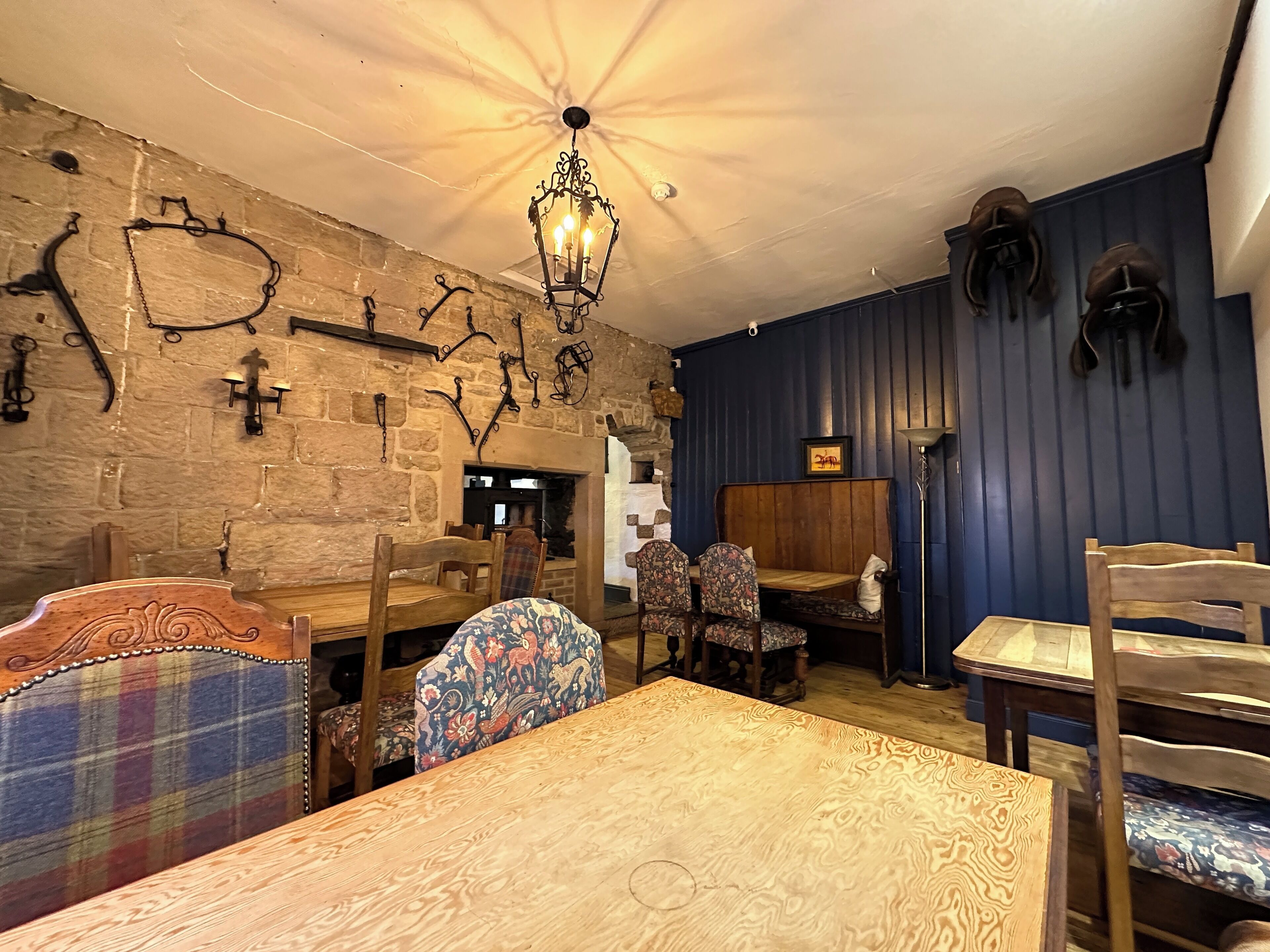 Un interior rústico con paredes de piedra, muebles de madera y una araña.