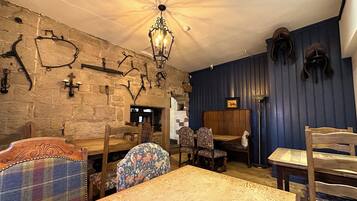 Un interior rústico con paredes de piedra, muebles de madera y una araña.