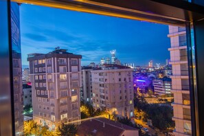 A cityscape at dusk with illuminated buildings and a clear view of the skyline. - Sherlock Homes Hotels (Istanbul)