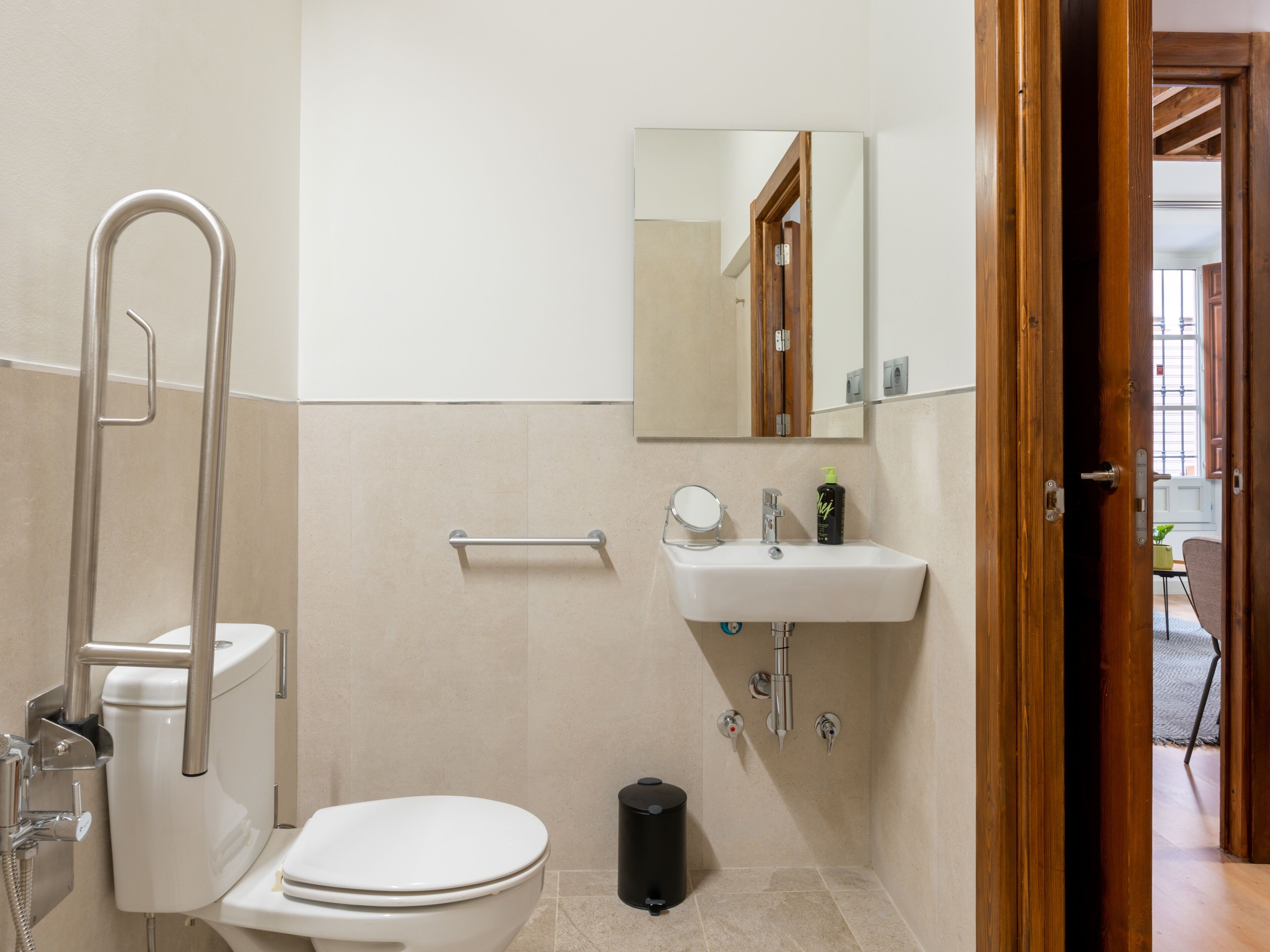 A bathroom with a toilet, a sink, a mirror, and a shower.