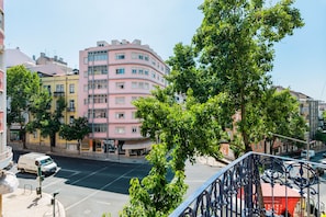 A multi-story building with a pink facade, surrounded by trees and other buildings. - Conde 3BDR Luxury (Lisbon)