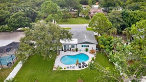 A modern house with a swimming pool, surrounded by lush greenery and a well-maintained lawn. - Luxury Oasis w/ Private Pool - 5-Minutes to Beach (Seminole)