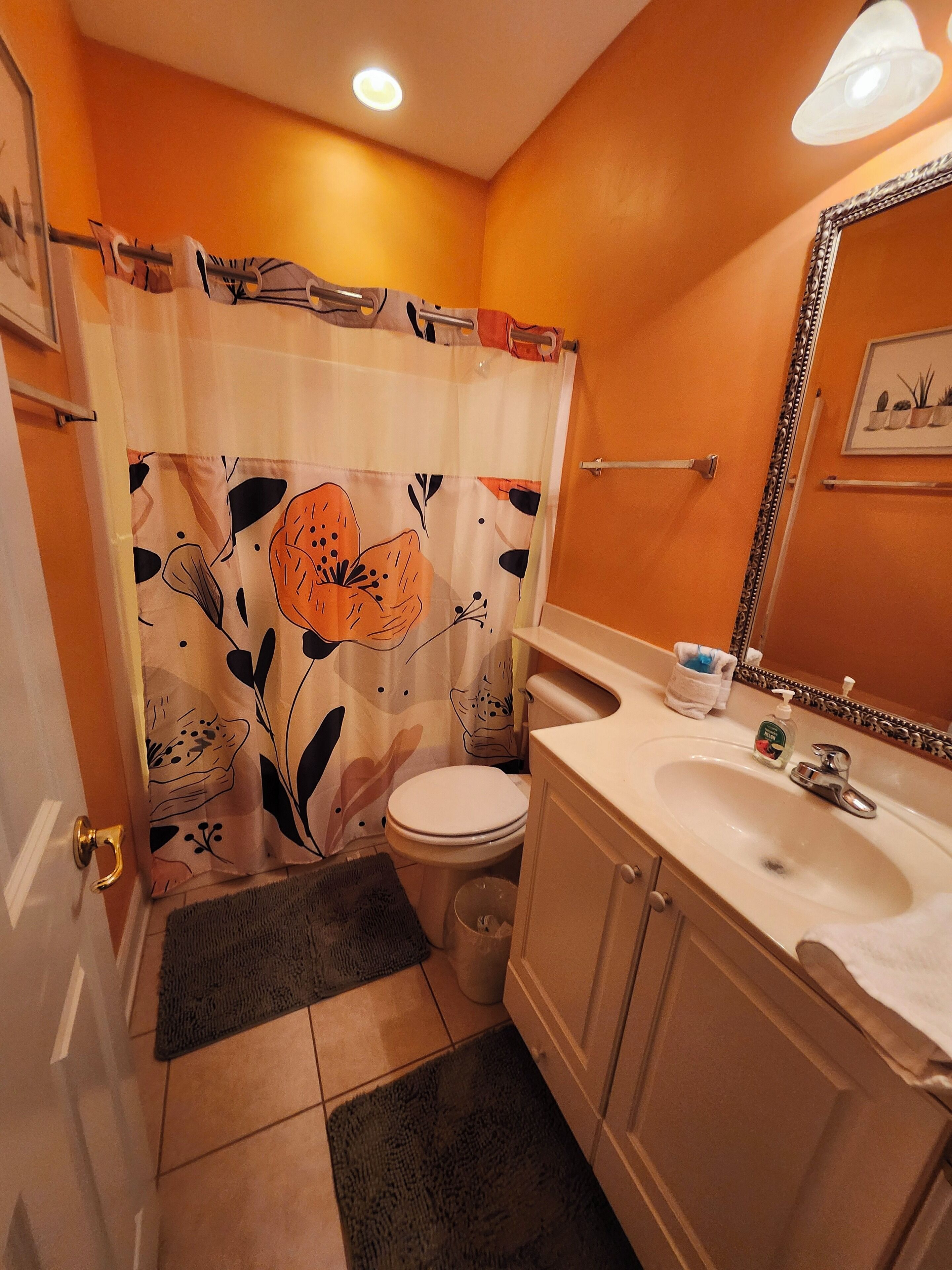 Une salle de bain avec des toilettes, un lavabo et un rideau de douche.