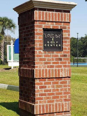A brick structure with a sign reading "Tupelo Bay Golf Center".