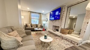 Un salon moderne avec un canapé, une table basse et un téléviseur.