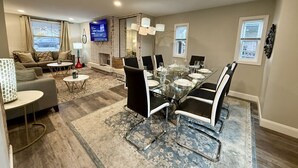 Un vaste espace de vie comprenant une table à manger, des chaises et un téléviseur.