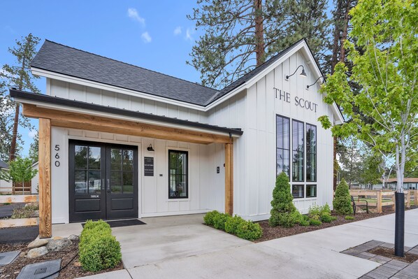 A modern building with a white exterior and black doors, labeled "THE SCOUT."