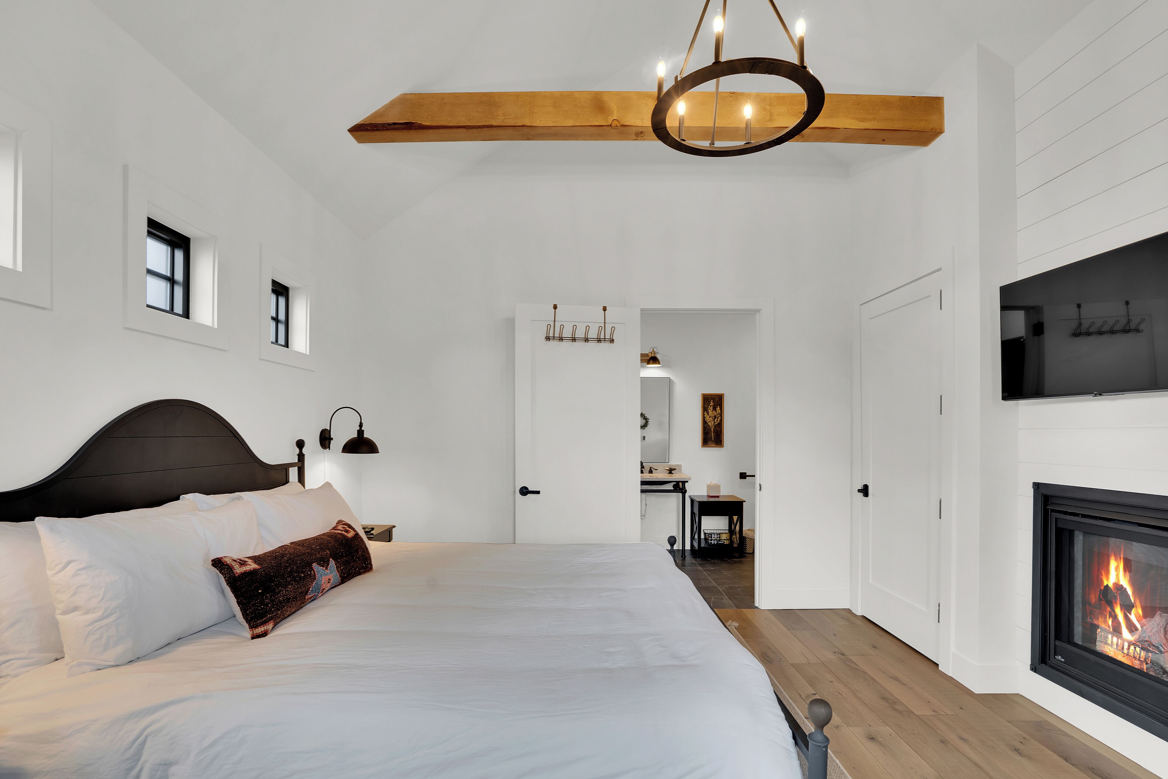 Un dormitorio con una cama grande, una chimenea y una viga de techo de madera.