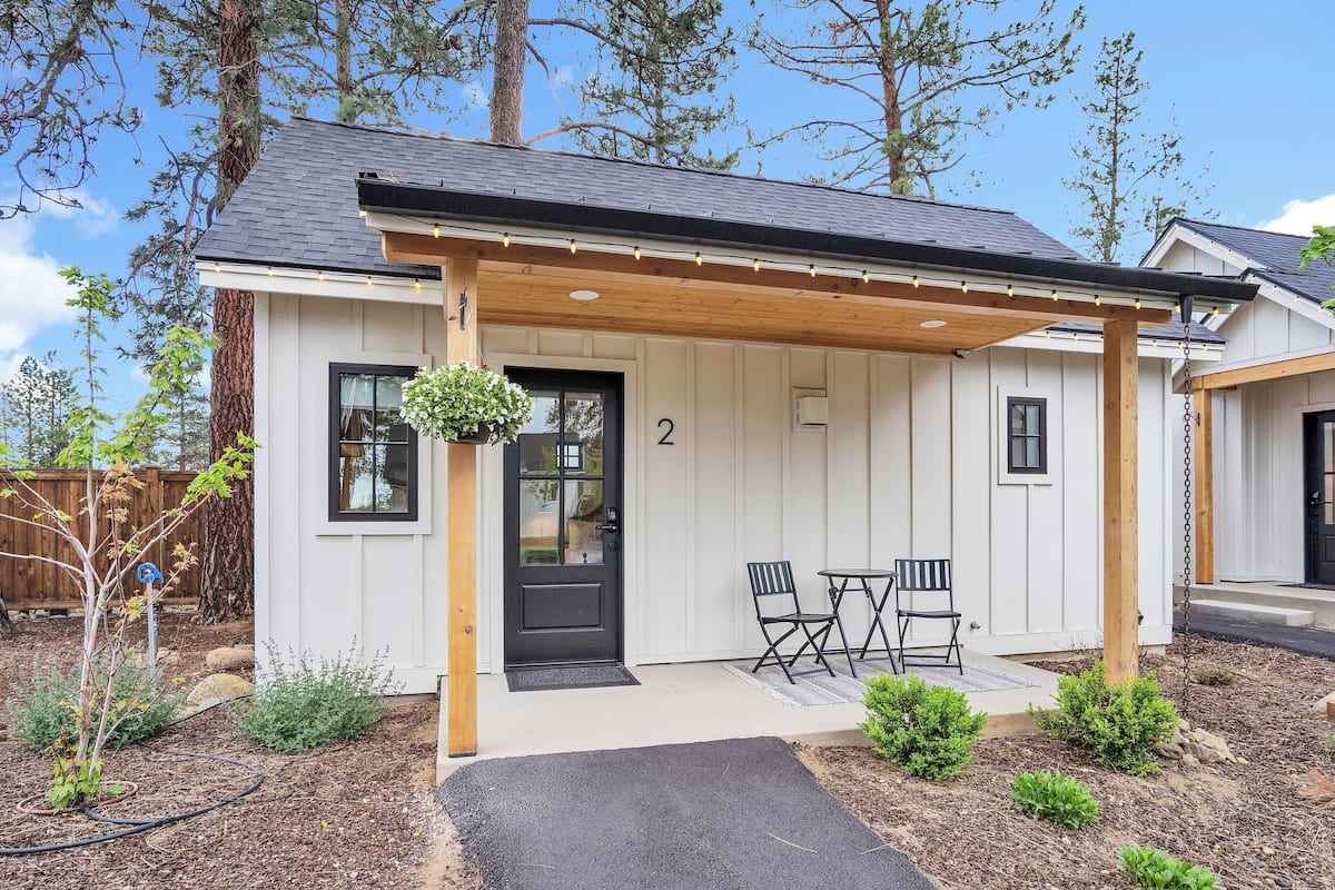A single-story house with a covered porch, a black door, and a number '2' on the wall.