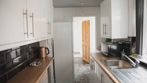 Een koelkast met diepvriezer, een microgolfoven, een oven, een kookplaat