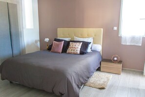 Une chambre à coucher avec un lit, une table de chevet et une fenêtre.