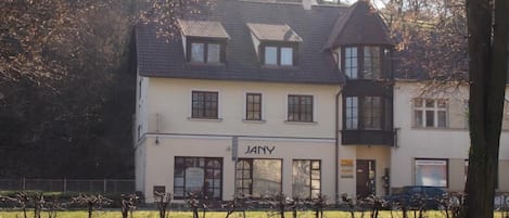 Un edificio de dos pisos con un letrero que dice "JANY" en la planta baja.