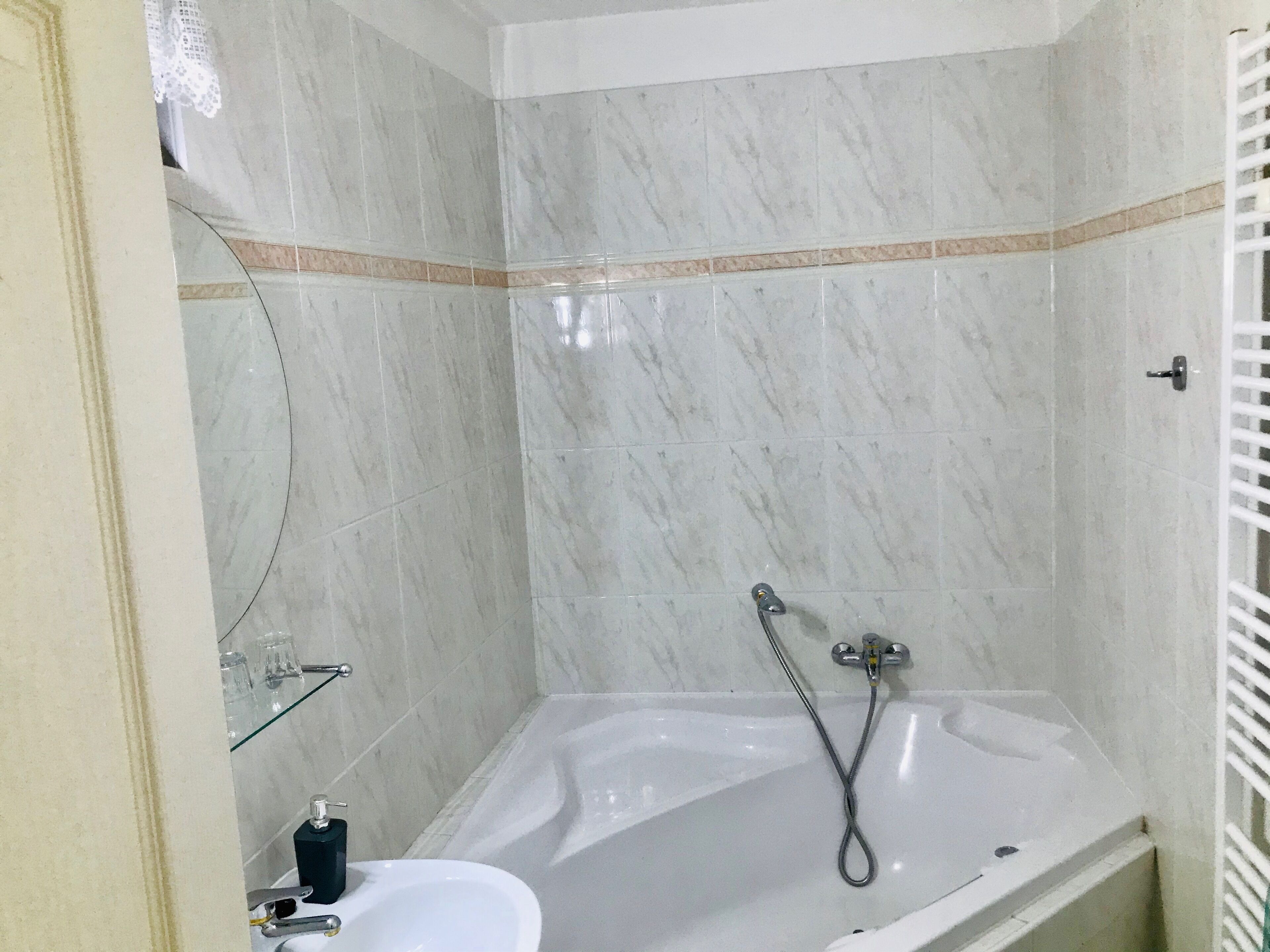 Une salle de bain équipée d’une baignoire, d’un lavabo et d’une douche à parois en verre.