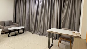 Una sala moderna con un sofá, una mesita redonda y una mesa de comedor.