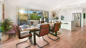 A modern dining area with a wooden table, leather chairs, and a view of the outdoors.