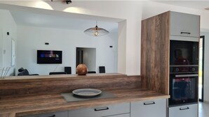 A modern kitchen with a wooden countertop, built-in appliances, and a flat-screen TV. - Villa 8pers with view and exceptional swimming pool (Bargemon)