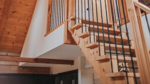 A wooden staircase with a handrail and a ceiling fan.