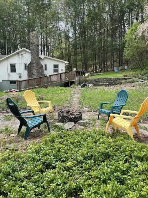 Relax in a serene natural setting with Adirondack chairs on a spacious deck.