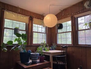 Relax in a serene space with a chair, table, and lush greenery.