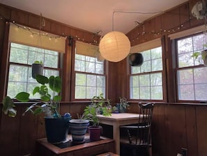 Relax in a serene space with a chair, table, and lush greenery.