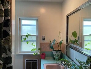 Bathroom with a window, sink, and mirror.