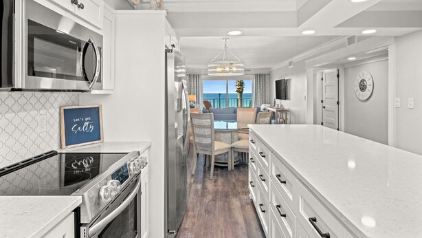 Una cocina moderna con una isla grande, electrodomésticos de acero inoxidable y vistas al exterior.