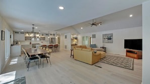 A spacious living area with a dining table, sofa, and television. - Lakefront Hideaway on Hartwell (Lavonia)