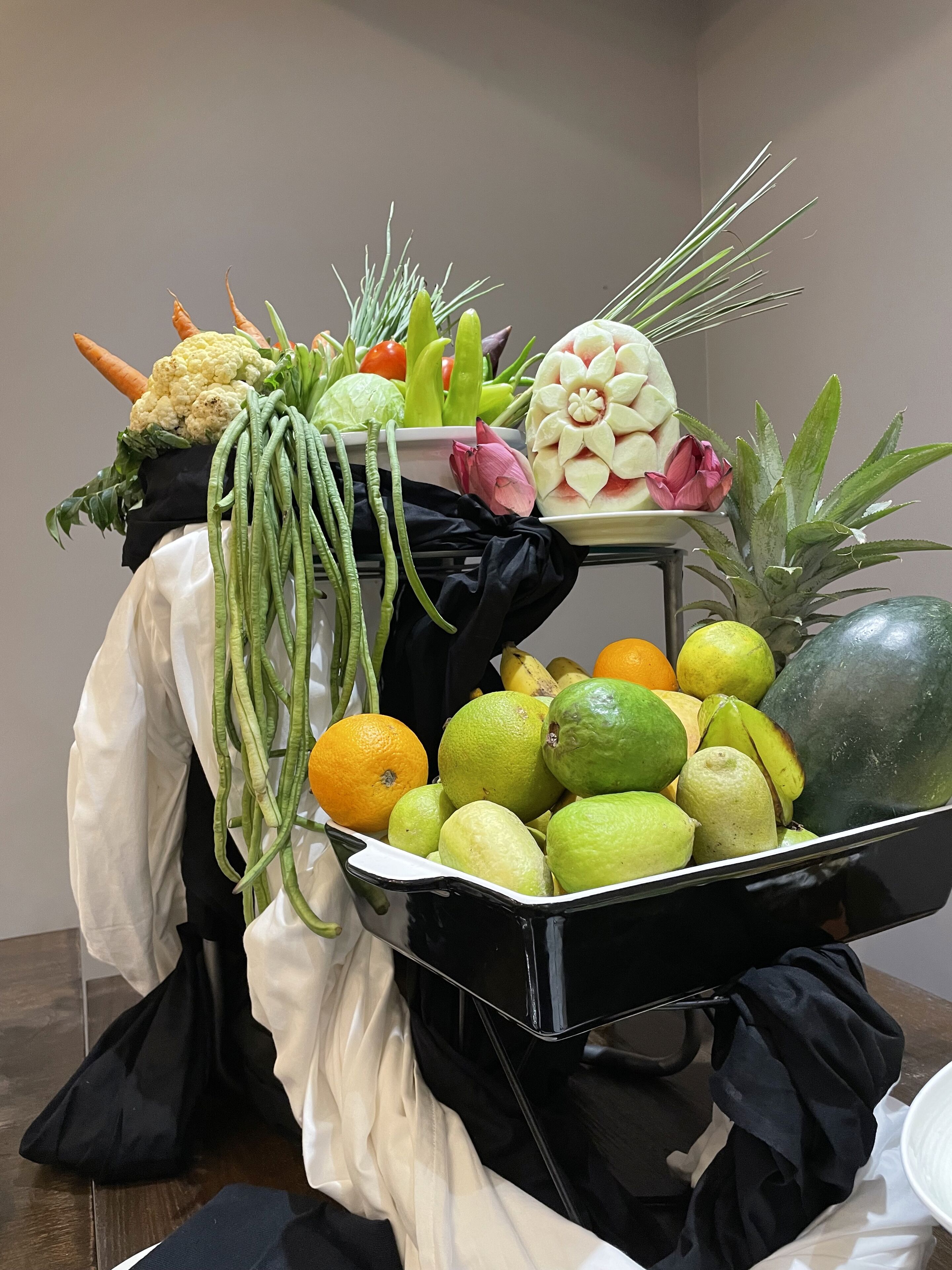 Exhibición de frutas y verduras con diversos tipos de productos, incluyendo zanahorias, coliflor y cítricos.