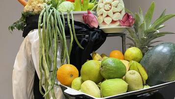Exhibición de frutas y verduras con diversos tipos de productos, incluyendo zanahorias, coliflor y cítricos.