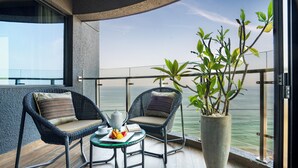 A balcony with wicker chairs, a table with fruits and a teapot, and a large potted plant. - MaRadha Colombo (Colombo)