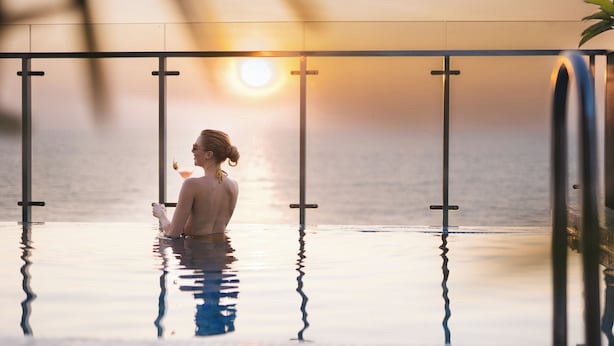A person in an infinity pool with a sunset view. - MaRadha Colombo (Colombo)