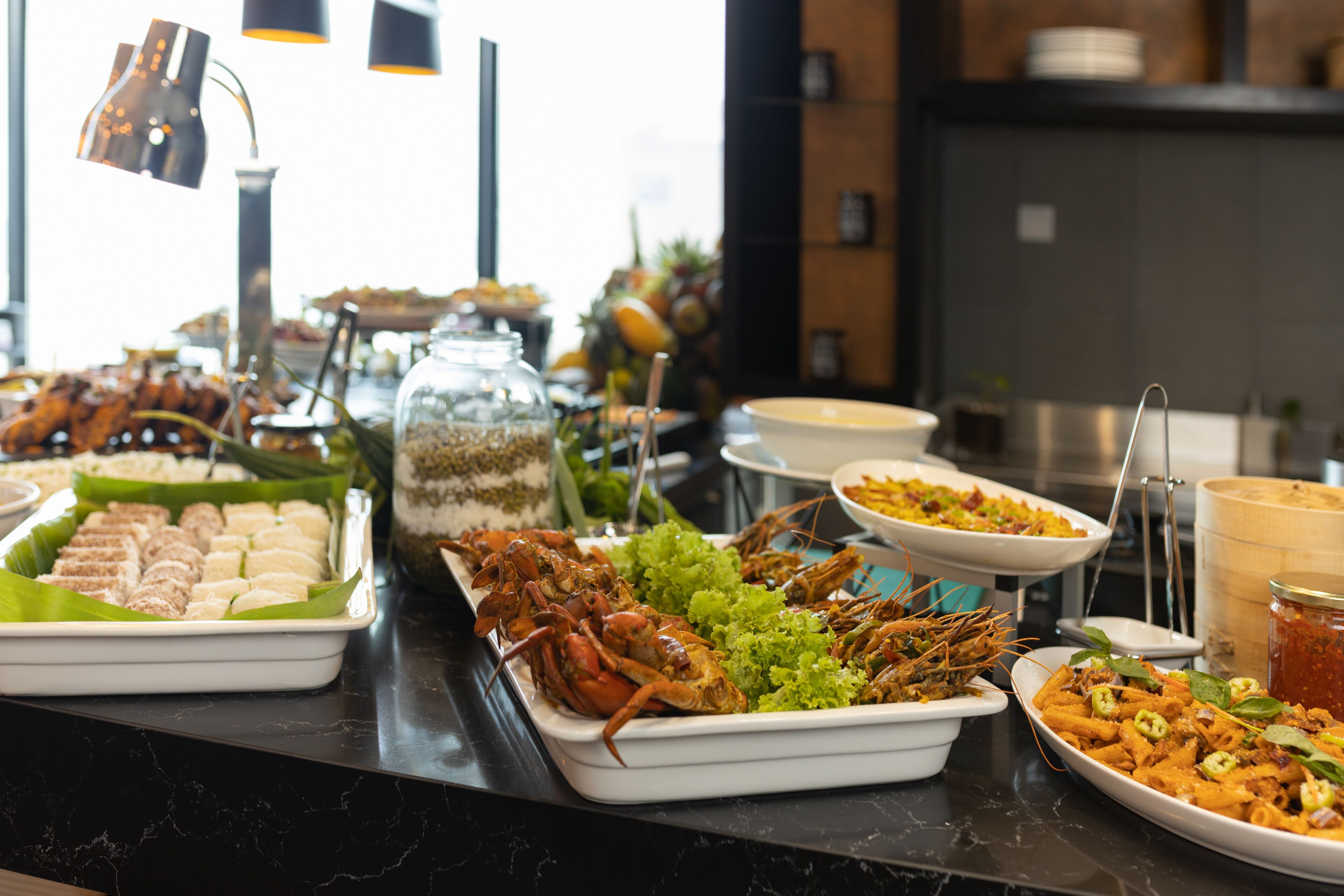 Un bufé con diversos platos, incluyendo mariscos, ensaladas y pasta.