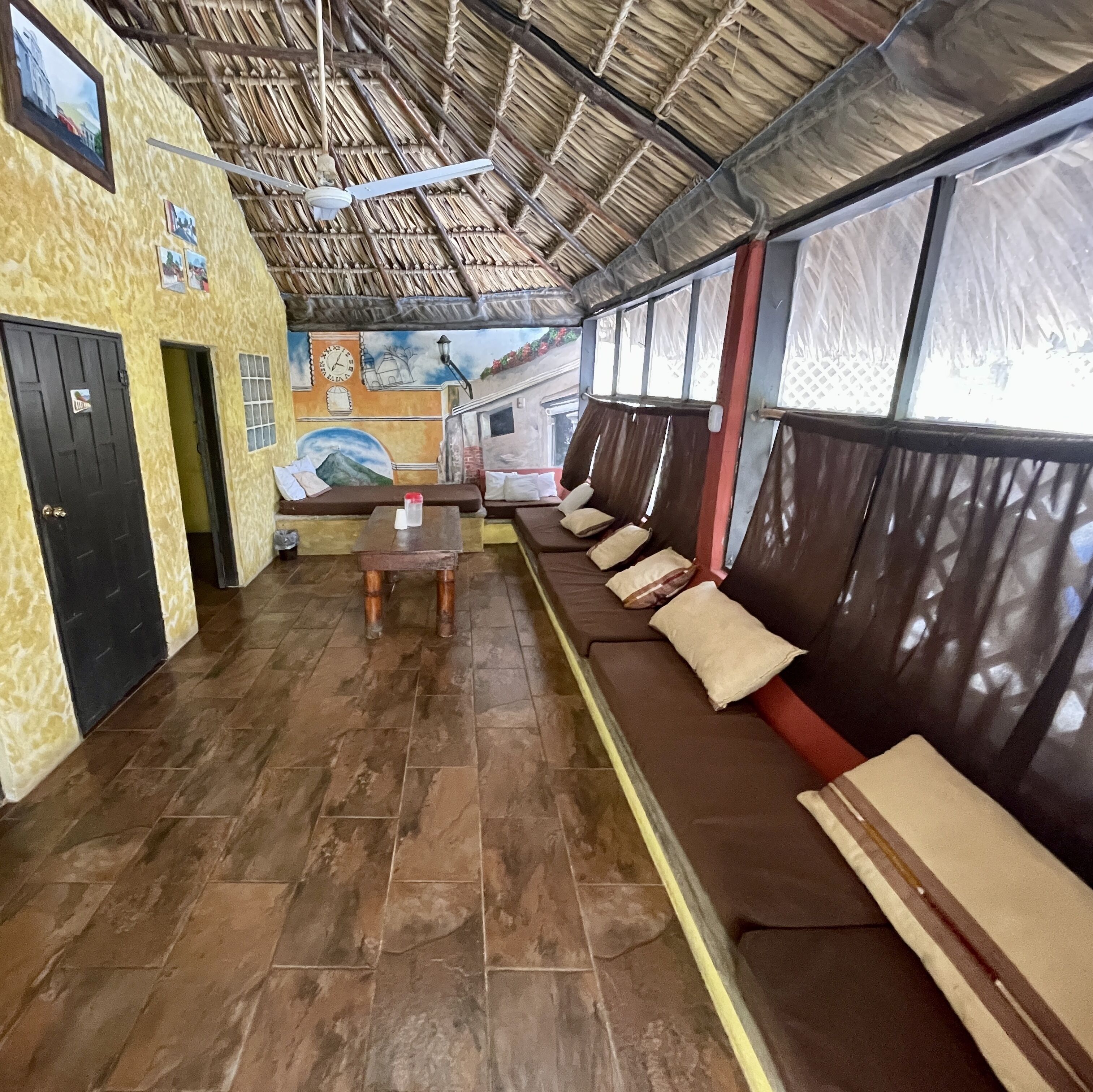 A room with a long bench, a table, and a mural on the wall.