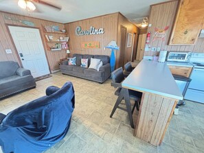 A cozy living area with a sofa, a dining table, and a kitchen area with a toaster.