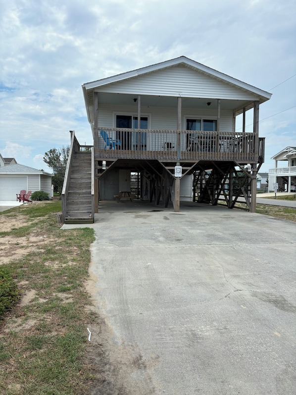 A two-story building with a balcony and a staircase leading to the upper floor.