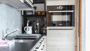 Uma cozinha moderna com forno Bosch, pia e chaleira.