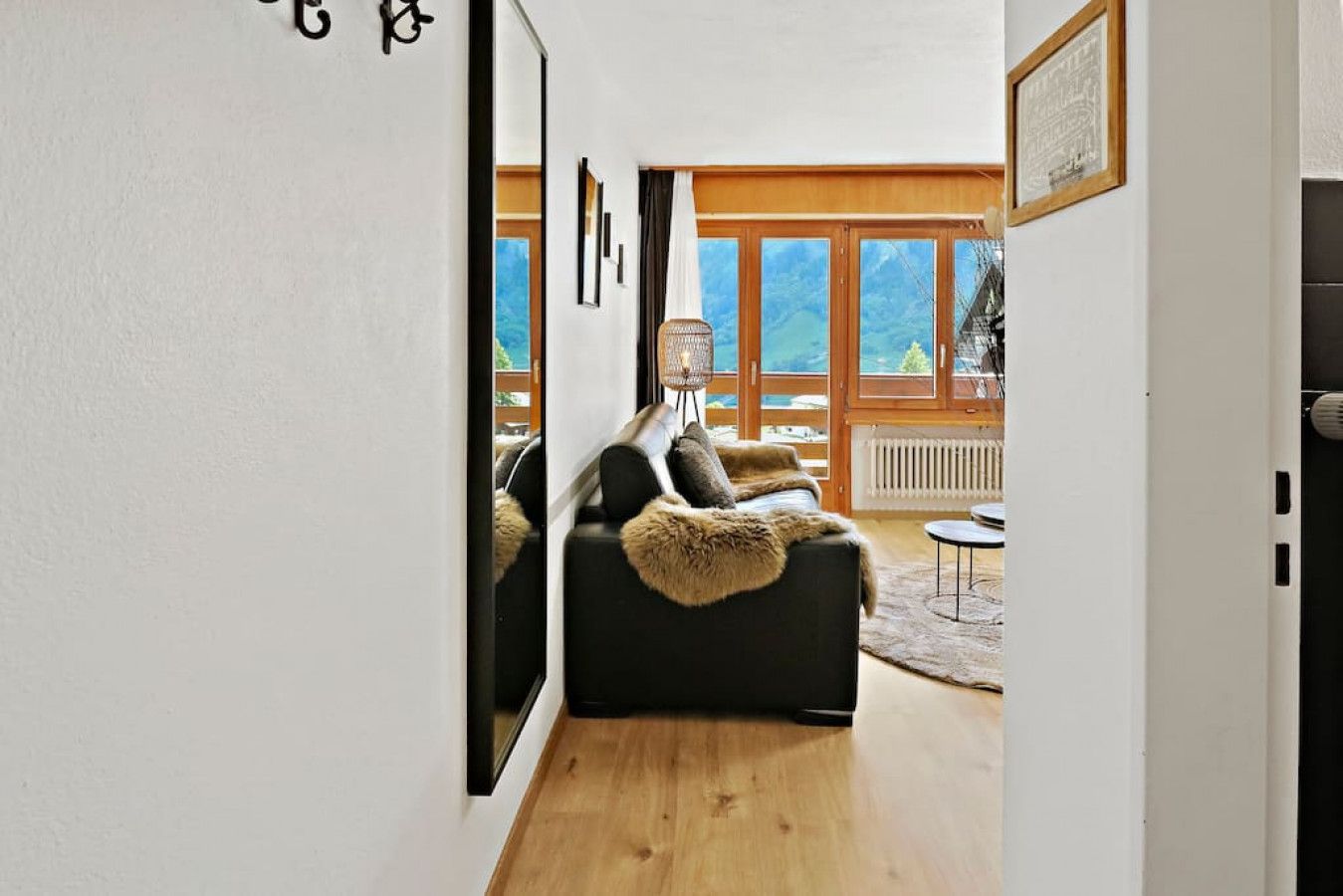 Una sala de estar moderna con un sofá, una mesita y vistas al exterior a través de amplios ventanales.
