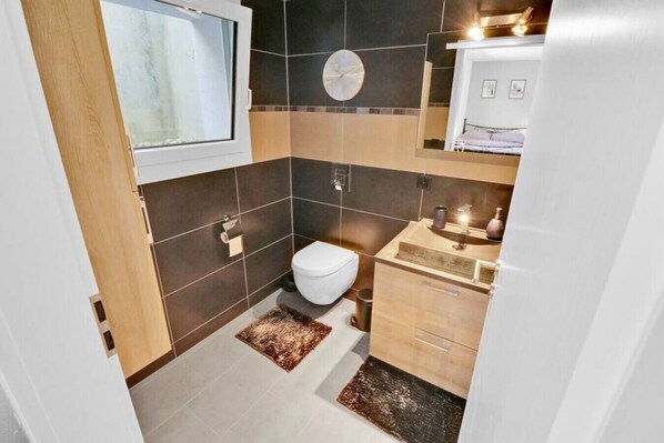 A compact bathroom with a toilet, sink, and mirror.