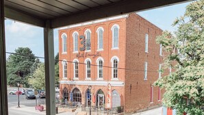 A brick building with a porch and a street view.