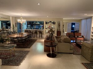 Un'ampia zona giorno con tavolo da pranzo, divani e una cucina sullo sfondo.