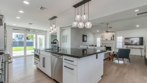 A modern kitchen with a large island, stainless steel appliances, and pendant lighting. - Beautiful Furnished Arcadia Home with Camelback View Off Exeter (Phoenix)