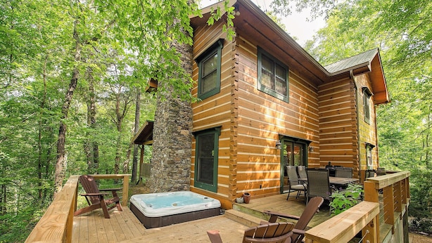 A log cabin with a hot tub, deck chairs, and a stone wall. - Chilhowee-Big log cabin with hot tub by the Ocoee (Benton)