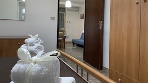 A hotel room with a wooden wardrobe, a mirror, and a bed. - Apartment San Lorenzo in Villa (San Lorenzo)