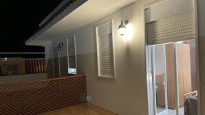 A balcony with a tiled floor, a lattice fence, and a sliding glass door leading to a bedroom. - Apartment San Lorenzo in Villa (San Lorenzo)