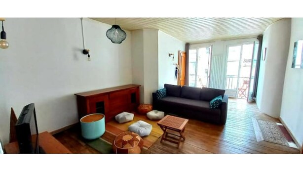 A living room with a sofa, a coffee table, a TV, and a wooden cabinet. - Loft en Duplex Avec vue sur Plage et Chenal (Dieppe)