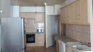 A kitchen with wooden cabinets, a stainless steel refrigerator, a microwave, and a dishwasher. - Loft en Duplex Avec vue sur Plage et Chenal (Dieppe)